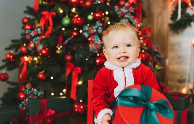 Bébé en costume de Père Noël rouge et blanc.