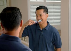 homme en polo bleu fumant une cigarette