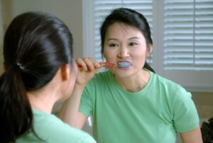 femme en t-shirt vert à col rond tenant une sucette rouge