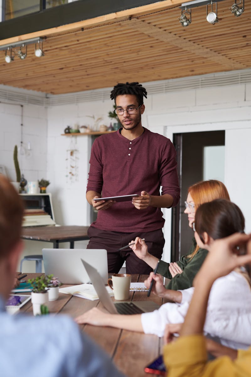 De jeunes professionnels participent à une séance de brainstorming dans un environnement de bureau moderne.